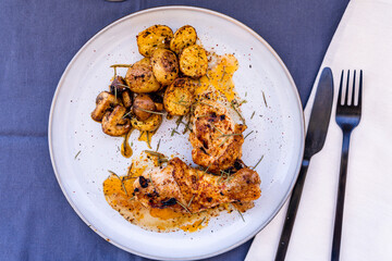 Top view of some delicious baked chicken legs with rustic potatoes and some delicious boletus sauteed in EVOO and Spanish paprika.