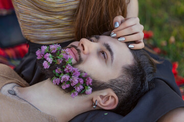 Obraz na płótnie Canvas man with flowers in his beard close-up