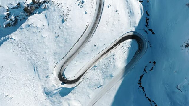2022 - Excellent bird's eye view of a car driving along the S curve from wintry Davos to St. Moritz, Switzerland.