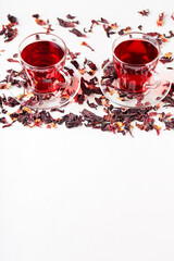 Cup of hibiscus tea rosella, karkade, red sorrel on a white background. Hibiscus tea and dry hibiscus petals. Diuretic drink with herbs. Top view. Copy space