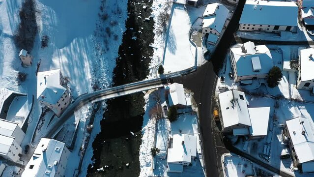 2022 - Excellent overhead view of cars driving through the wintry town of Susch, Switzerland.