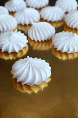 White delicious meringue lies on a golden surface. confectionery