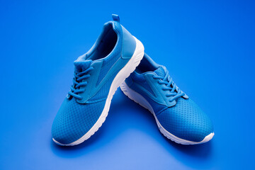 pair of comfortable sport shoes. sporty blue sneakers. shoes on blue background.