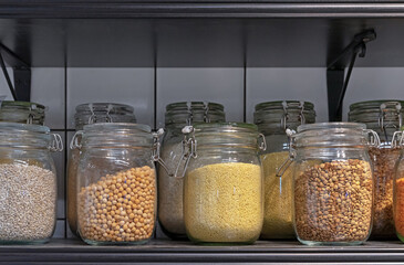 Glass jars with various cereals and grains. Foods storage concept .
