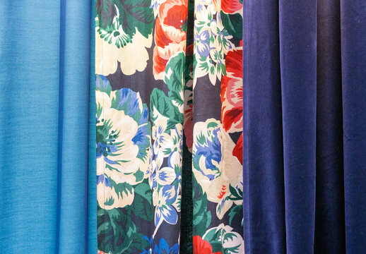 Blue And Dark Blue Curtains On The Edges And A Bright With Floral Ornament Curtain In The Middle.