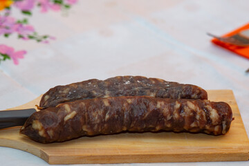 gut liver sausage in the foreground on a table