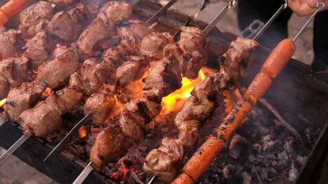 Barbecue pieces of pork. Shashlik. The process of frying meat on the grill. Slow motion. Smoke from fire. Cooking barbecue in nature. Boiling fat on pork. Holidays of the CIS. 1st of May. Shashlyk