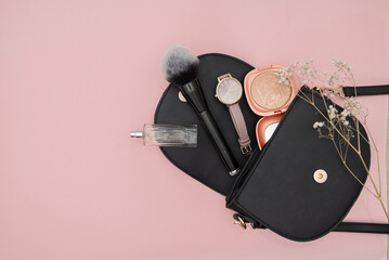 Bag with cosmetics isolated on pink background
