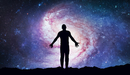 Naklejka premium Silhouette of human stand against bright galaxy and space. Meditation and dreams. Esoterica and psychology. Elements of this image furnished by NASA