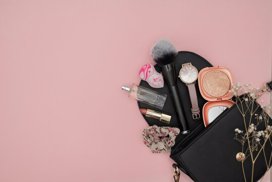 Bag with cosmetics isolated on pink background