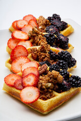 Delicious waffles with strawberries, walnuts and blackberries for a healthy and nutritious breakfast.