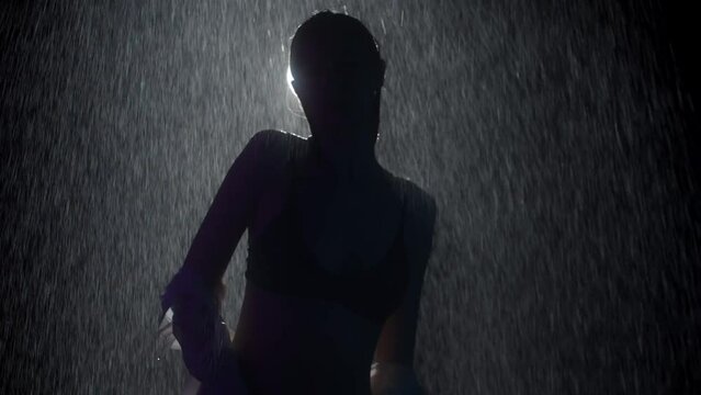 Hot young woman with nice body dancing under the rain