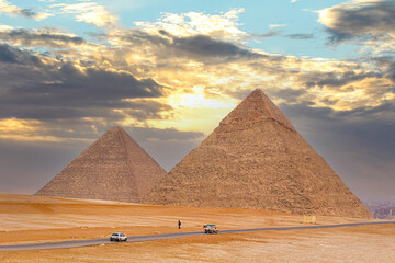 The Giza pyramids from the backside, a street leading to the pyramids