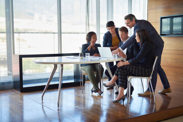Giving his input. Shot of a group of corporate businesspeople working in the boardroom.
