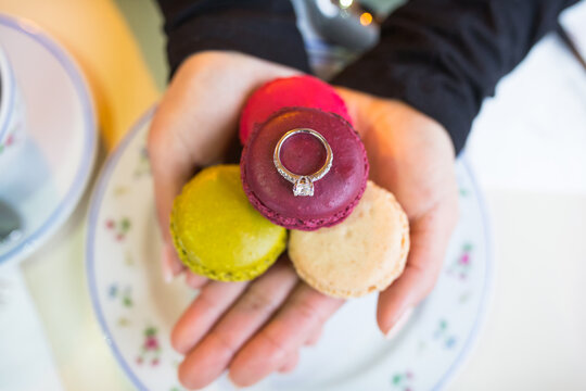 Engagement ring on a hand with maccarons colors