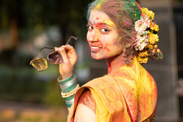Holi festival of color, a beautiful young girl woman lady in indian attire saree with dry organic...
