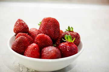 Ripe strawberries in a white bowl. Selective focus, close-up