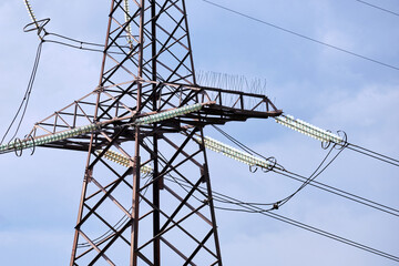 High voltage tower with electric power lines divided by safe guard bushing transfening safely electrical energy through cable wires. Electricity transmission on long distance concept