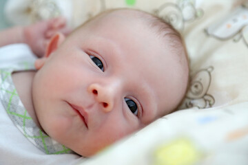the face of a newborn baby looking into the camera, close-up