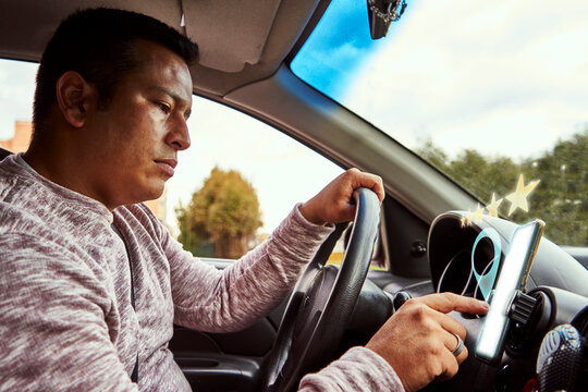 un joven conductor califica los servicios de ubicaci&oacute;n de una aplicaci&oacute;n en su tel&eacute;fono m&oacute;vil mientras pasea por el campo 