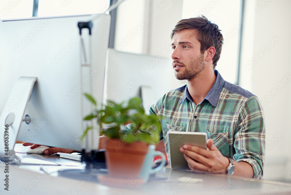Aufkleber progressive design. shot of a casually-dressed young man using a digital tablet at his desk.