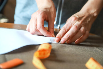 Obraz na płótnie Canvas Working process of a dressmaker. Closeup photo of craftsperson's hands