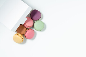 Sweet colorful macarons isolated on white background. Tasty colorful macaroons. Top view.