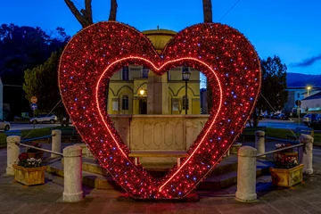 Fotobehang A big red heart with colored lights in the center of the village, to celebrate Valentine's Day, Vicopisano, Pisa, Italy © Marco Taliani