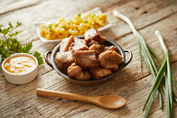 Homemade fritada a typical ecuadorian dish that consists on braised pork. It’s served on a white...