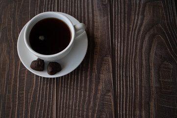 Mug of americano coffee with two chocolate hearts