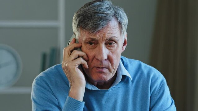 Close-up lonely pensioner talking on phone dissatisfied service elderly mature man yelling deceived aggressive angry grandfather emotionally speaking using smartphone sit in apartment grandpa swearing