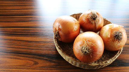 Onions basket. Onions in a wicker basket with space for text on left.
