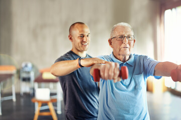 Forget about age, its time to engage. Shot of a senior man working out with the help of a trainer. - obrazy, fototapety, plakaty
