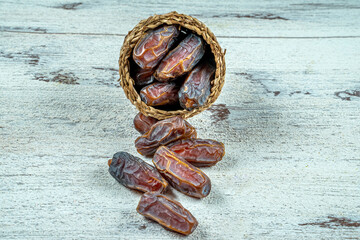 close up picture of dates palm fruit in cup on wooden table background. Dates palm fruit dry is snack healthy.