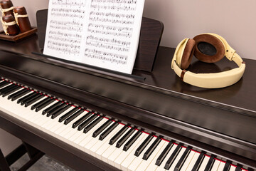 The piano keyboard, headphones, and sheet music blurred