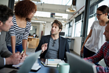 Putting their heads together. Shot of office workers talking in a meeting in an office.