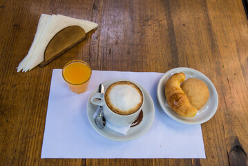 coffee with milk, orange juice and croissants