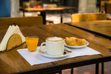 coffee with milk, orange juice and croissants