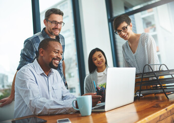 Working together to get the task done. Shot of businesspeople working together in the office.