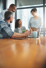 Working together to get the task done. Shot of businesspeople working together in the office.