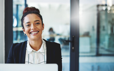 Reaching my goals one workday at a time. Shot of a young businesswoman using a laptop in a modern office.