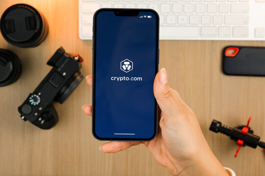 Female hand holding a smartphone with Crypto.com (cryptocurrency exchange) app on the screen. Content creator environment with keyboard, camera and mic. Rio de Janeiro, RJ, Brazil. February 2022