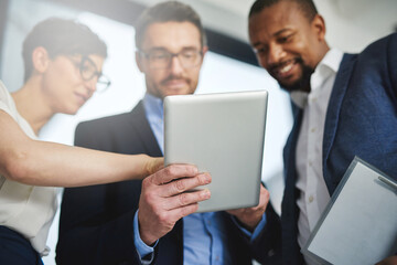Fototapeta premium Supporting team collaborations with technology. Shot of a team of colleagues using a digital tablet together at work.