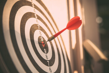 Bullseye or Bulls eye target or dartboard has dart arrow throw hitting the center of a shooting for...