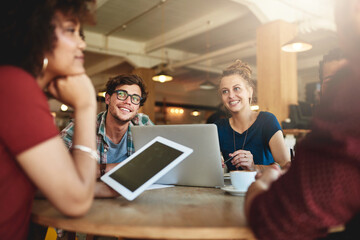 Enjoying the benefits of a study group. Shot of students studying in a coffee shop.