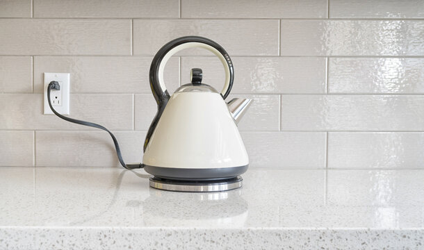 Electric Classic vintage kettle on a granite counter top against a ceramic background