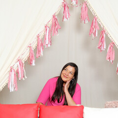 Latin adult woman with long straight hair in pink sweater is happy and comfortable at a picnic...