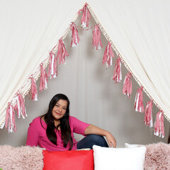Latin adult woman with long straight hair in pink sweater is happy and comfortable at a picnic...