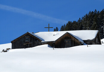 Indigenous alpine huts and wooden cattle stables on Swiss pastures covered with fresh white snow cover, Alt St. Johann - Obertoggenburg, Switzerland (Schweiz)