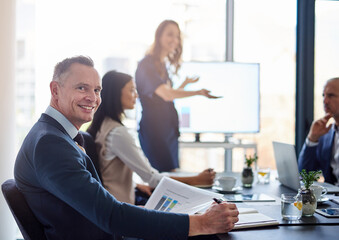 Its incredible what were able to achieve as a team. Portrait of a businessman sitting in a boardroom presentation with colleagues.